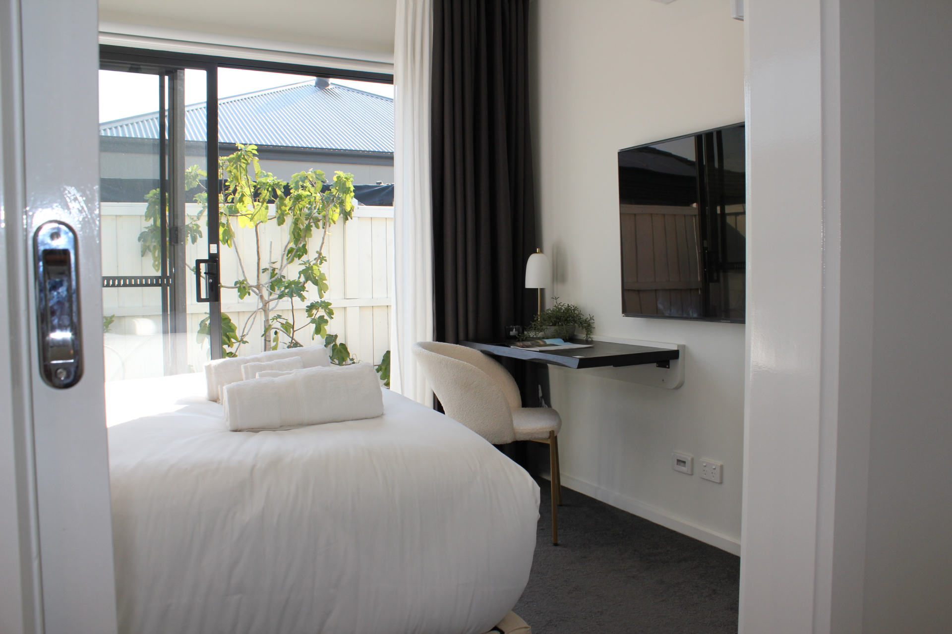 The private guest room with a soft white bed and garden view